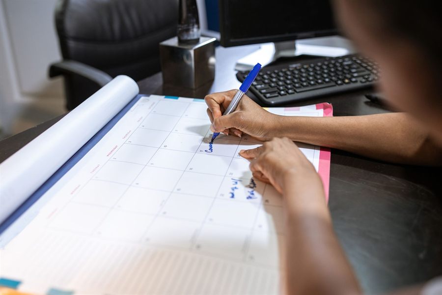 Person writing in a desk planner